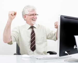 senior businessman winning in front of computer over white